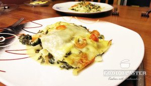 Vegetarische Lasagne mit Gorgonzola auf weißem Teller